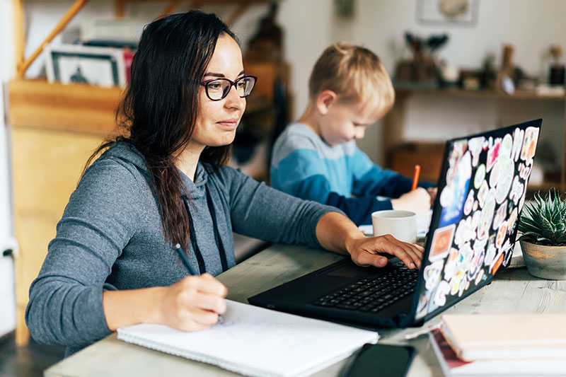 adult student doing school work next to her son